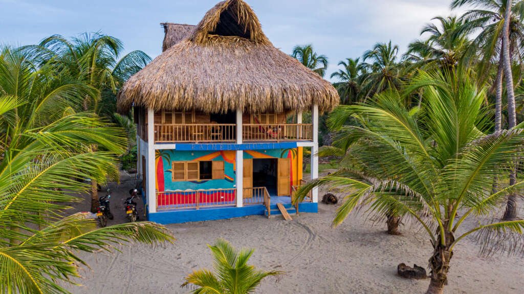 Vista aérea de la playa del Rainbow Hostel entre el mar Caribe y el río